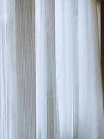 Striped door curtain gently swaying in a sunlit room, adding a touch of pattern and privacy.