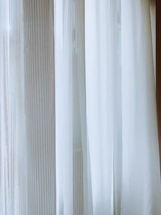 Striped door curtain softly hanging in a cozy living area, filtering gentle sunlight.