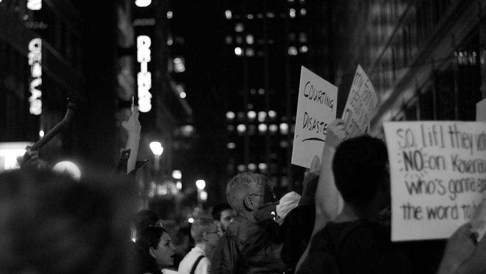 grayscale photography of crowd near buildings