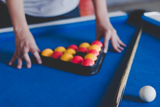 man preparing balls on pool table