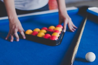 A technician adjusting the legs of a pool table.
