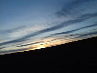 A serene landscape with a glowing horizon, evoking hope and new beginnings.