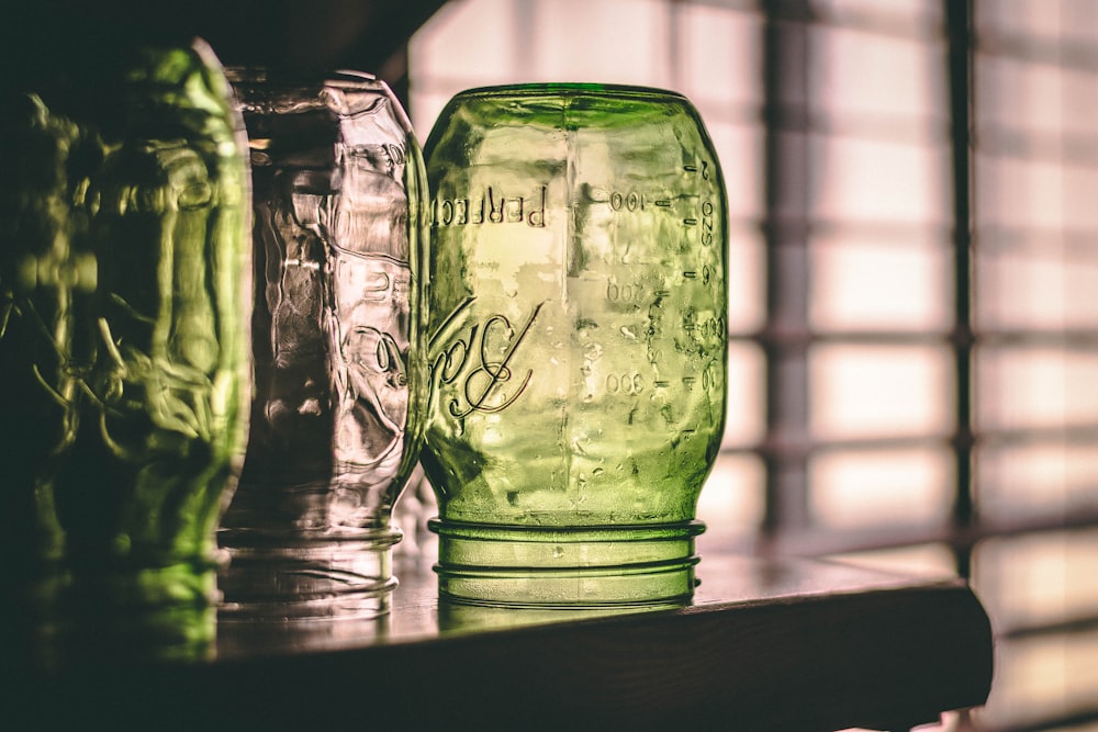 several assorted-color glass Ball Mason jars placed upside down