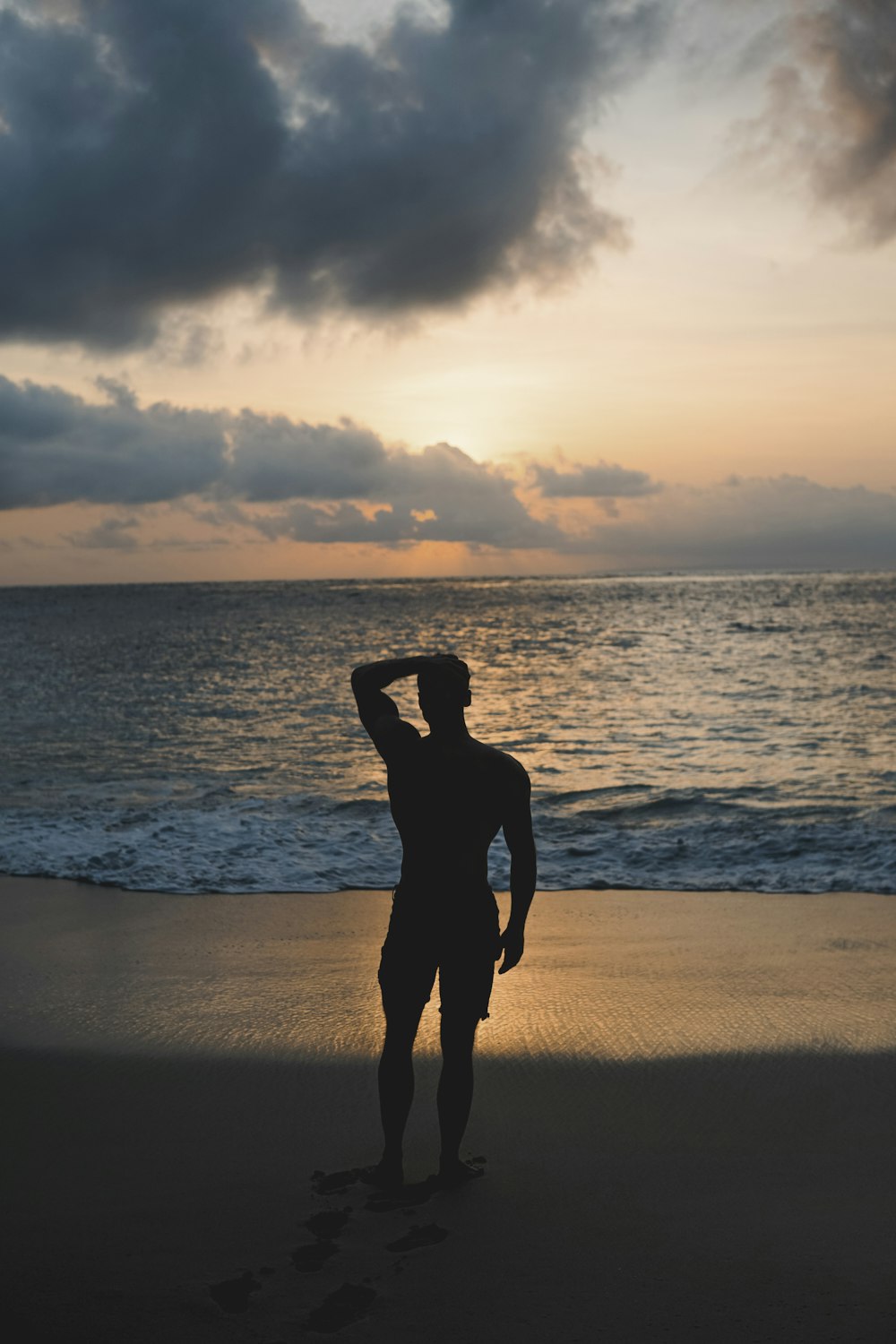 silhouette of man standing beside shore