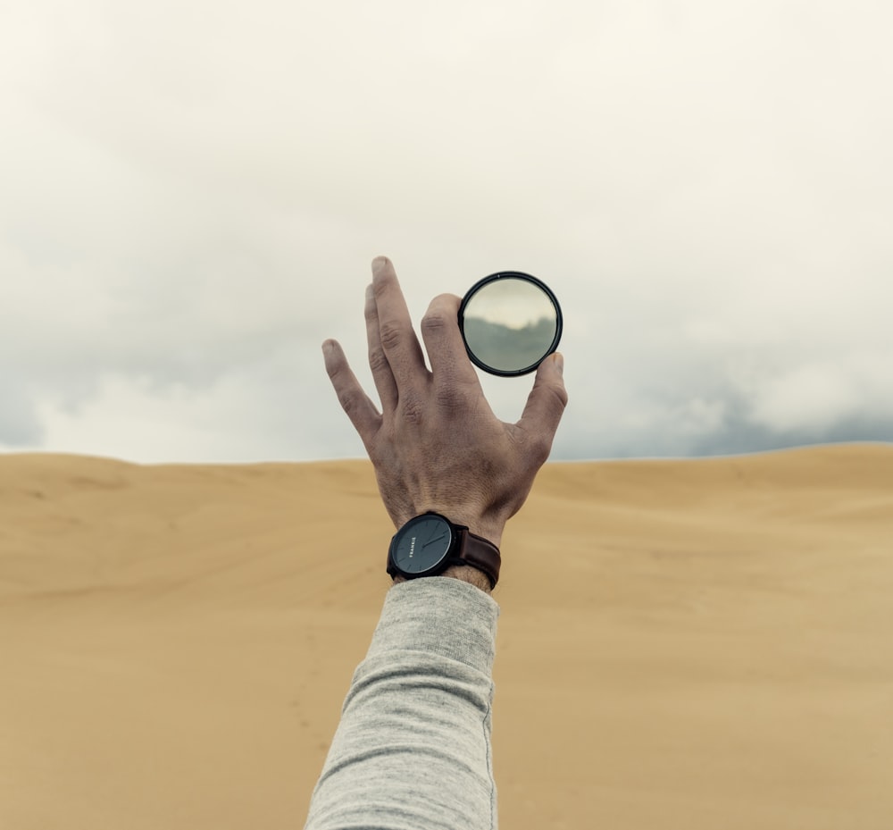 person holding lens during daytime