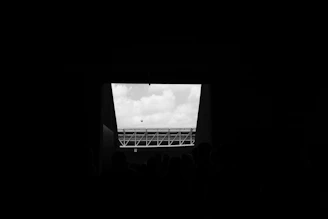 Wide shot of a group huddle under stadium lights, shadows stretching across the minimalist futsal pitch.