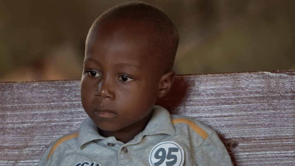 boy wearing gray button-up collared shirt