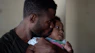 man carrying baby and kissing face