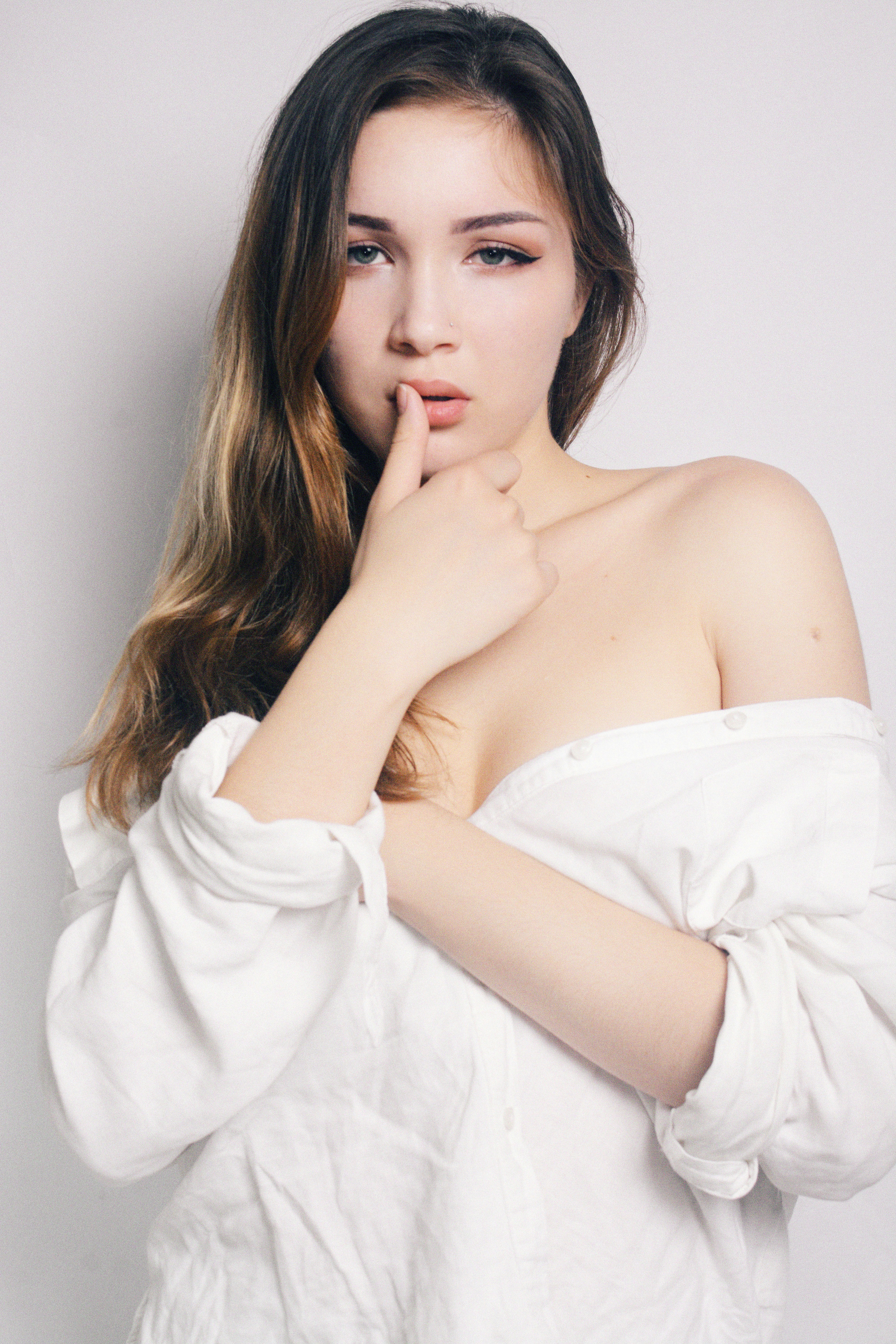 woman standing while right thumb on lips