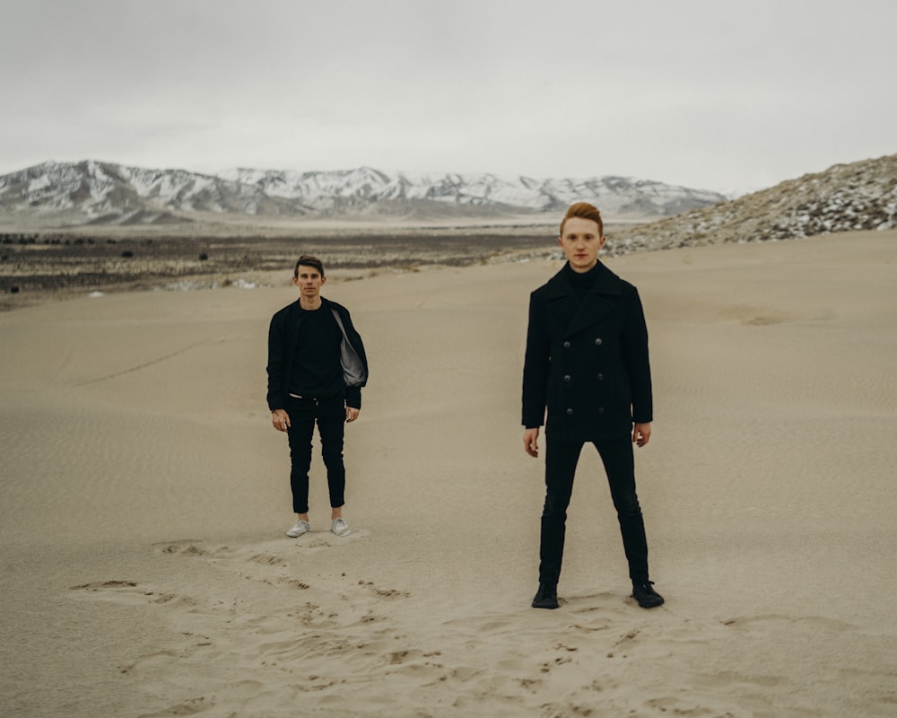 two person wearing black shirt standing on the desert