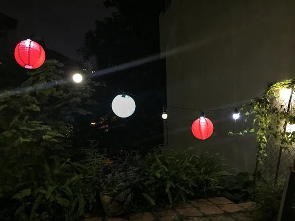 Nighttime event scene with glowing lanterns and soft pink uplighting creating a warm, inviting atmosphere.