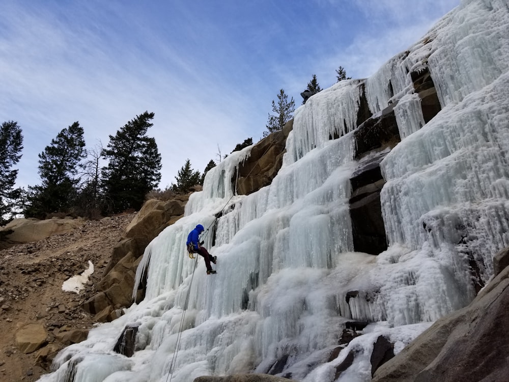 man rappelling down waterfalls