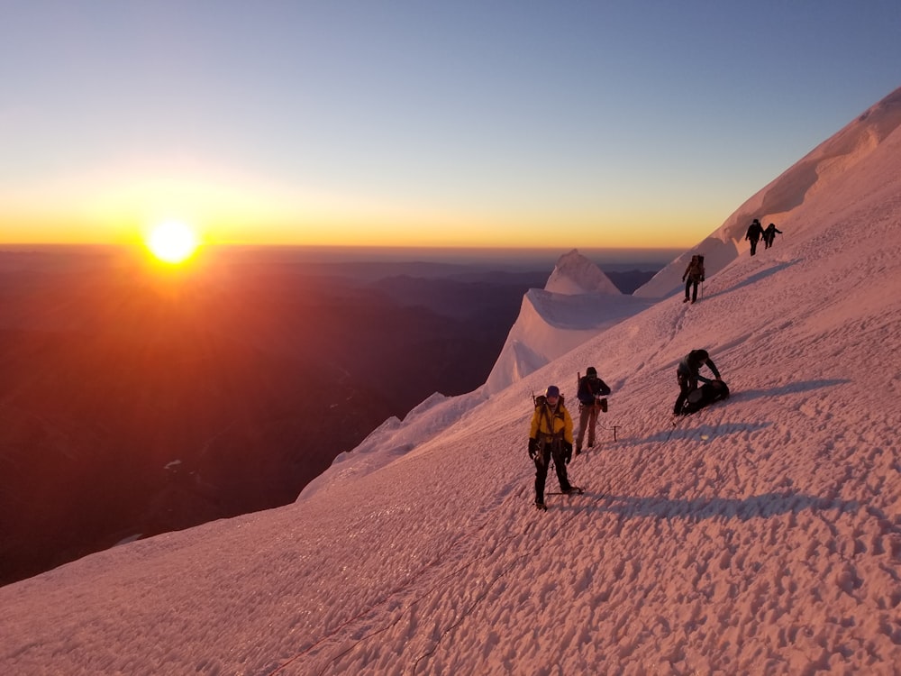 Personnes sur la montagne glaciaire au coucher du soleil