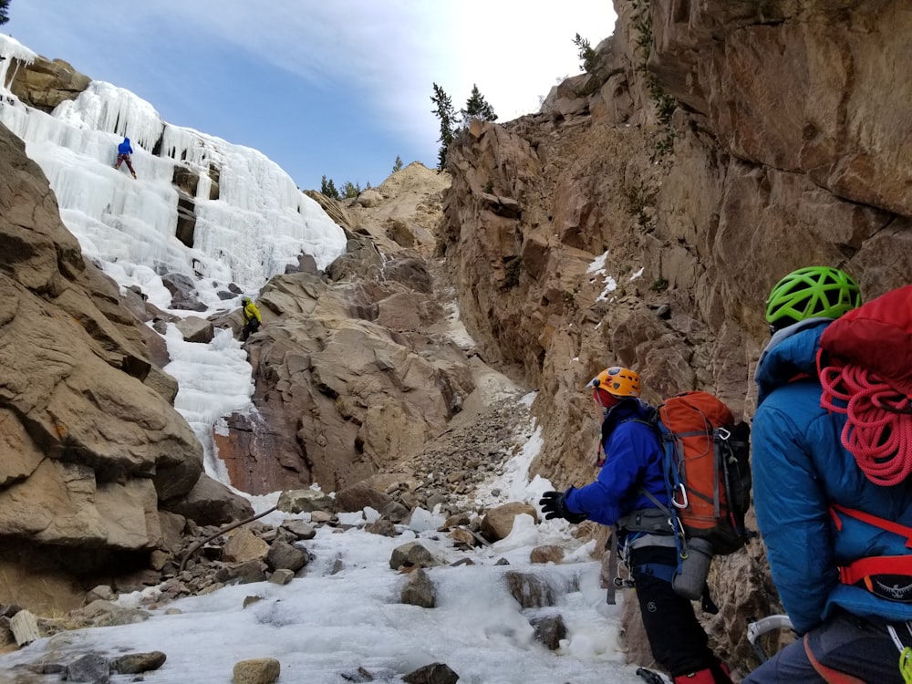 two person climbing mountain during daytime