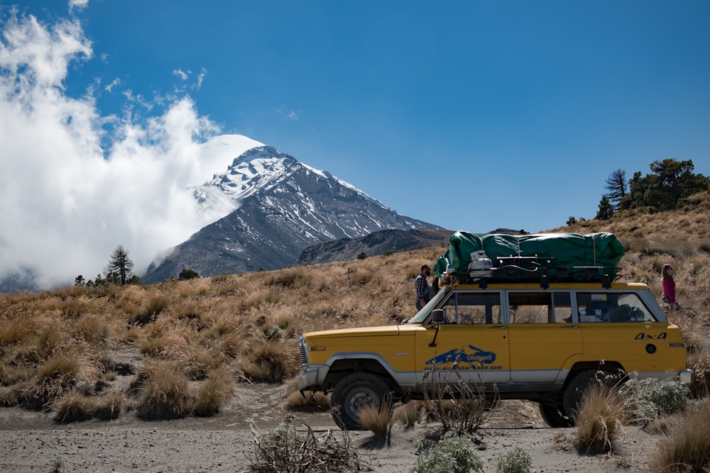 yellow SUV on road near mountain