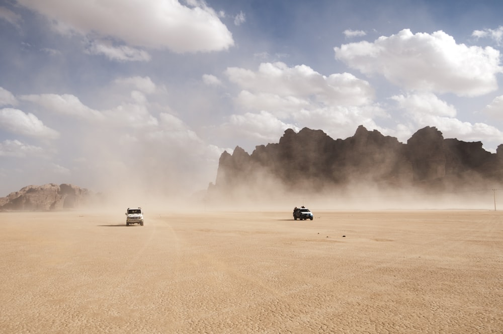 2 coches compitiendo en el desierto polvoriento