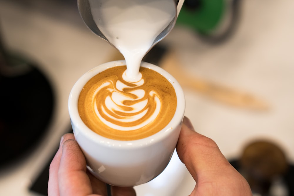 Milch wird auf Cappuccino gegossen