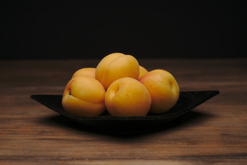 round yellow fruits on black plate