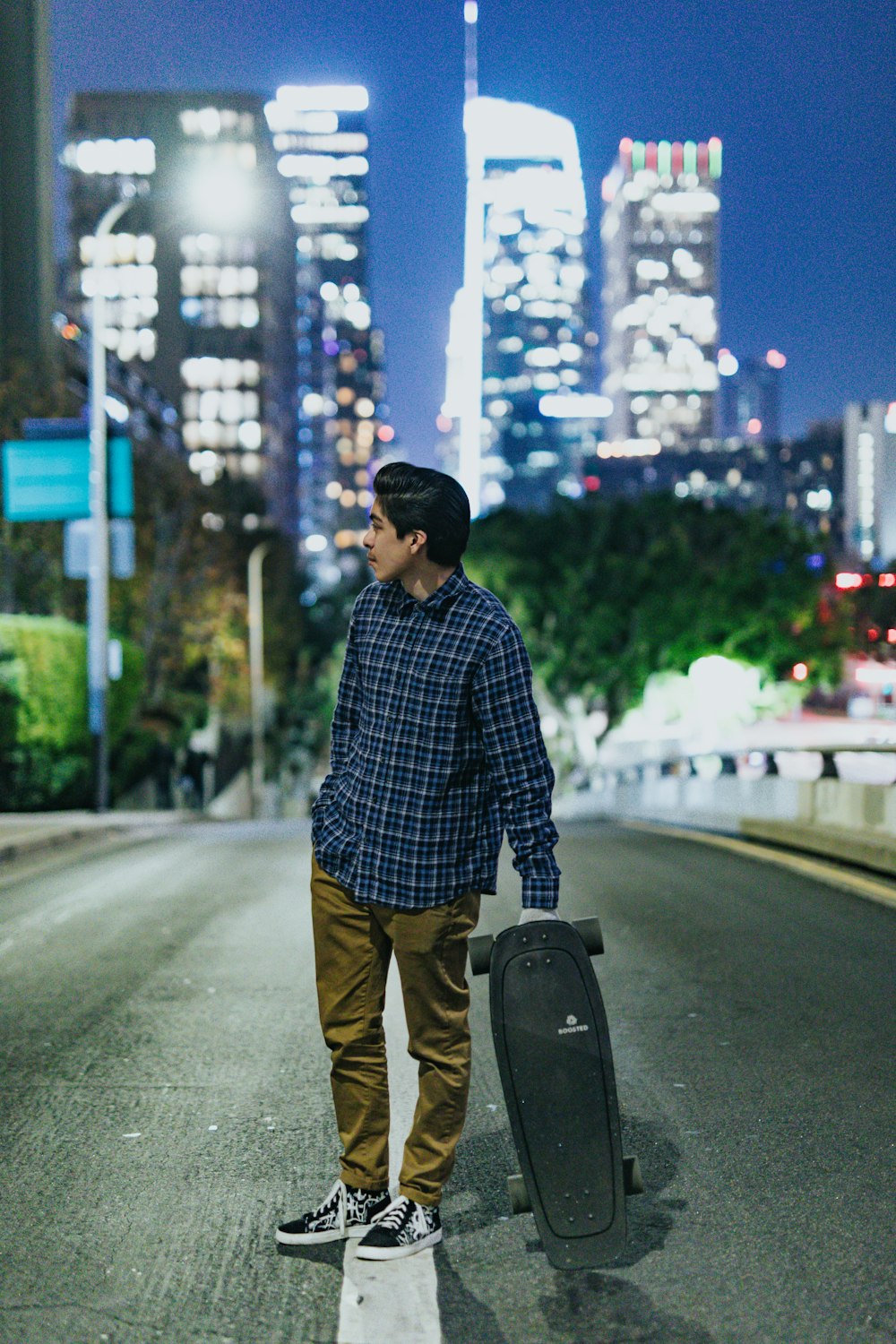 man holding black longboard