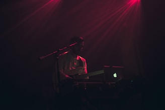Instructor giving an online guitar lesson with a laptop.