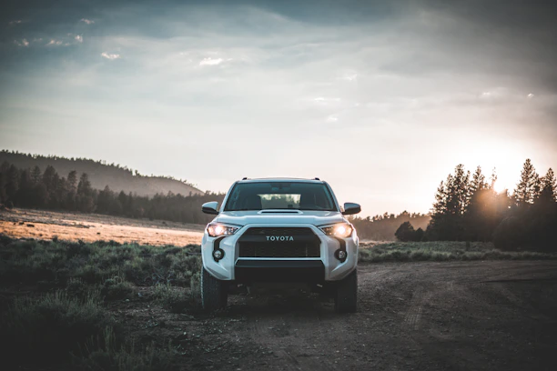 A sleek Toyota Land Cruiser VXR parked on a scenic road in Guinea at sunset.