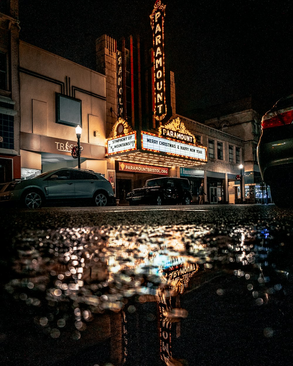 2 cars parked in front of lighted building