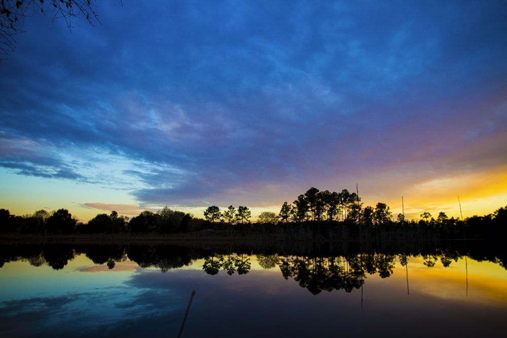 silhouette of island beside calm body of water