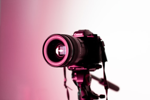 Close-up shot of a camera lens focusing on a corporate event setup.