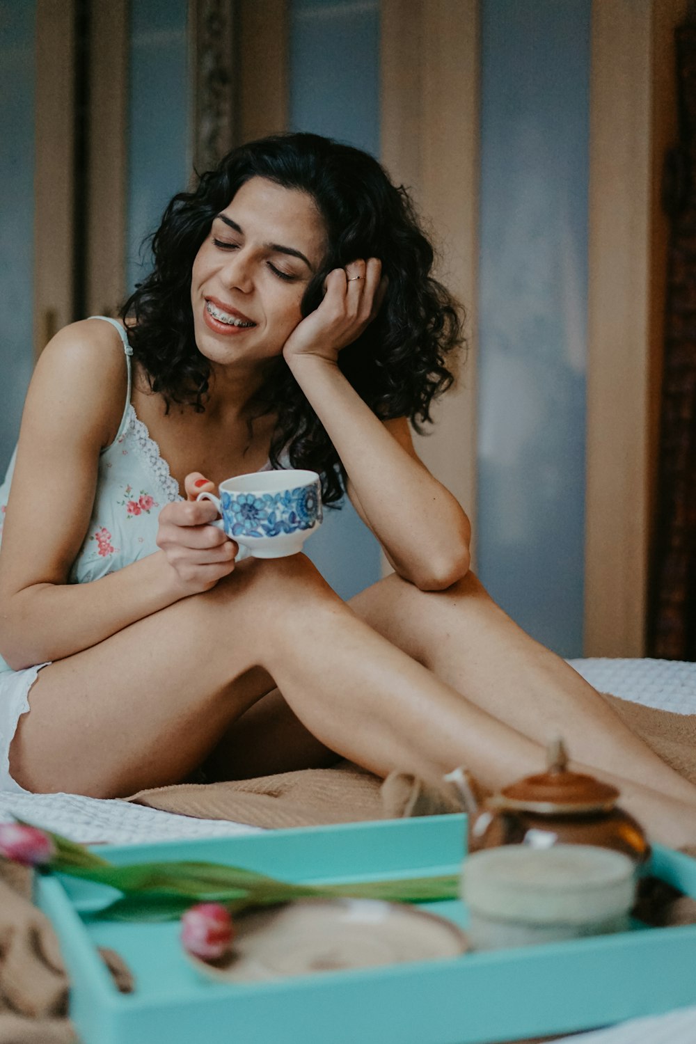 smiling woman holding ceramic teacup