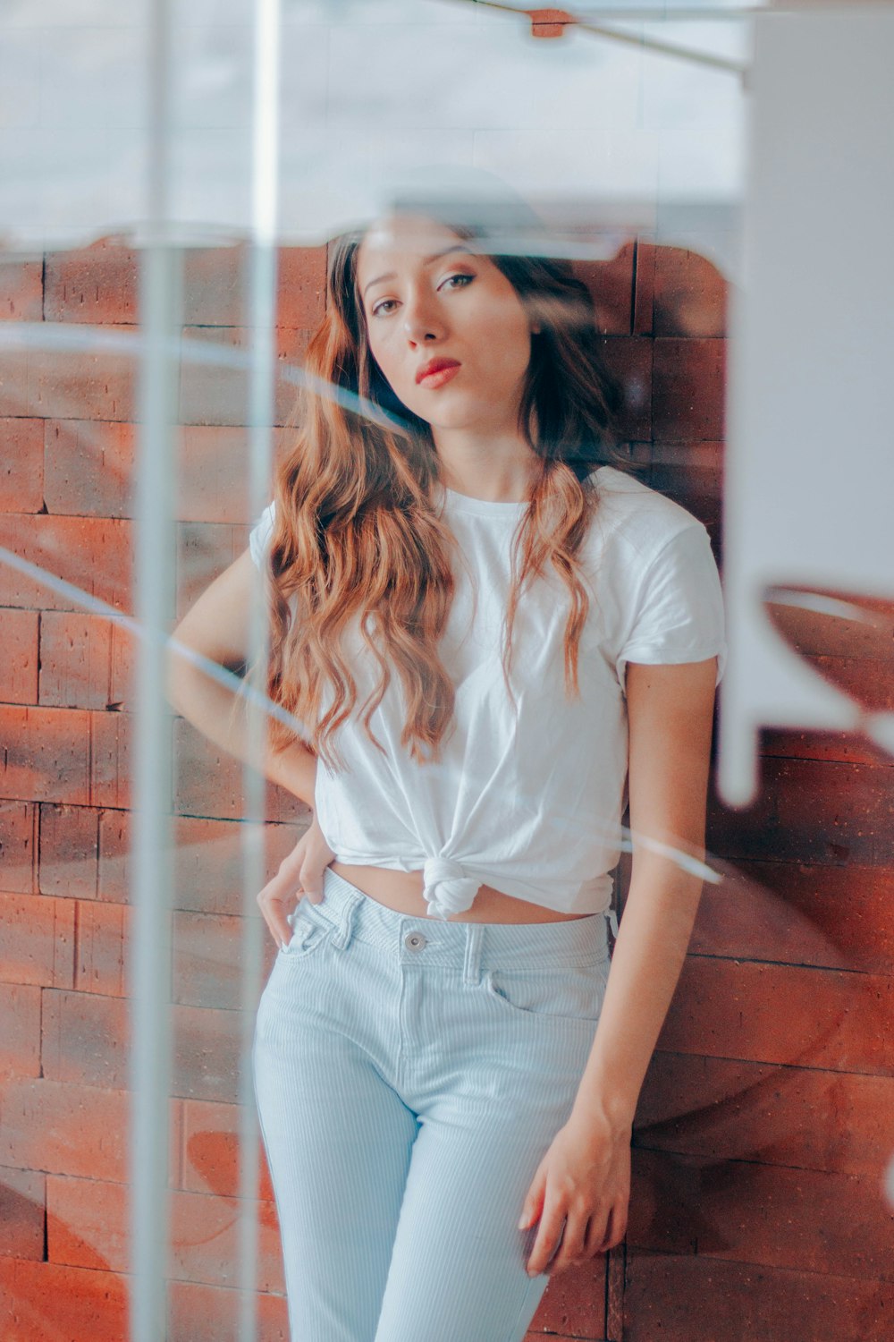 woman standing leaning on brick wall