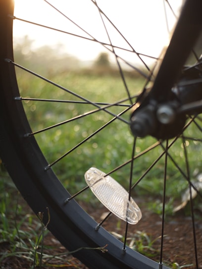 Close-up of a bicycle wheel with a vibrant cityscape reflected in the spokes