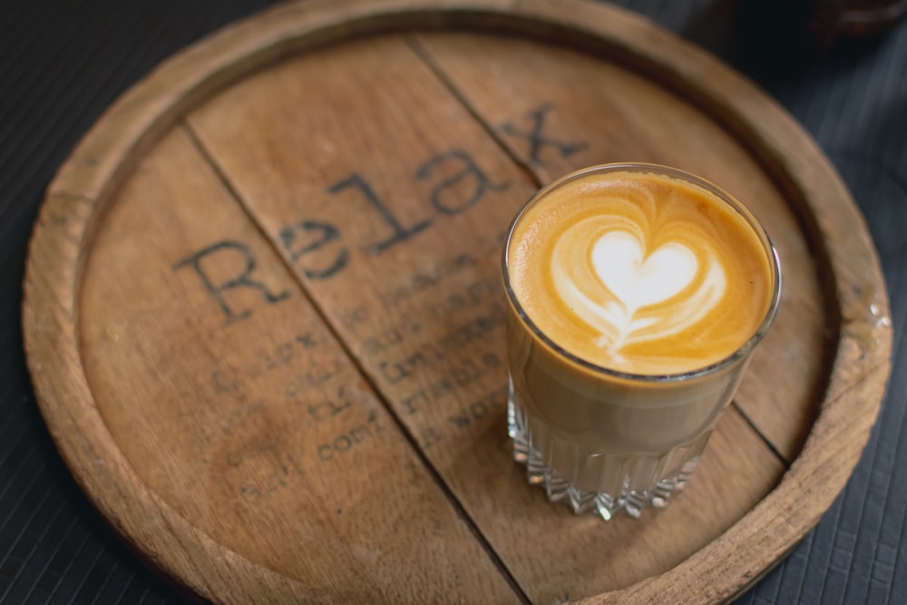 cappuccino in glass on brown wooden tray