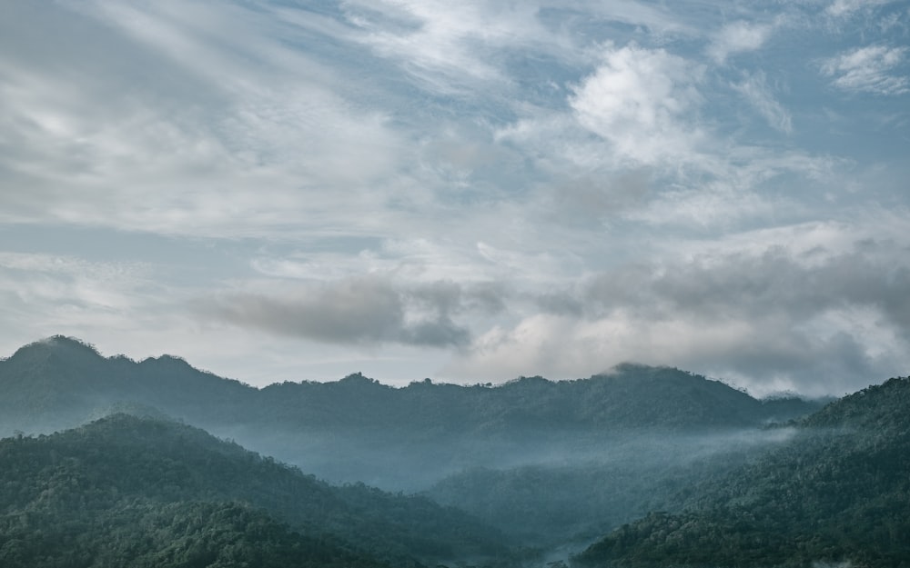 silhouette mountains under white sky