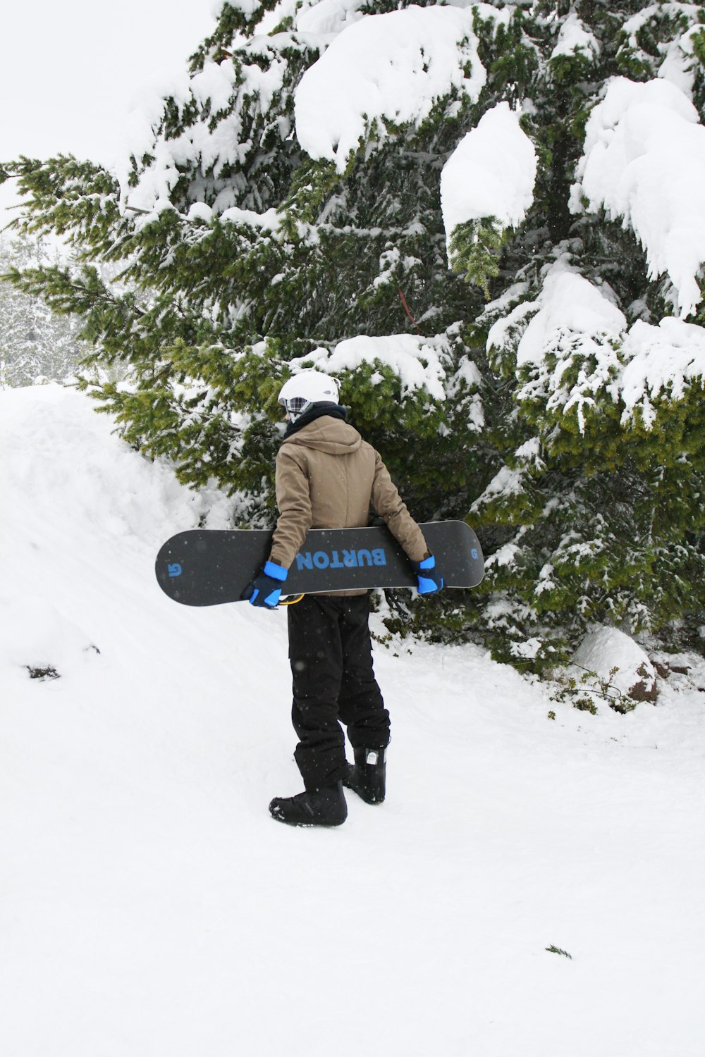 uomo in piedi mentre tiene lo snowboard