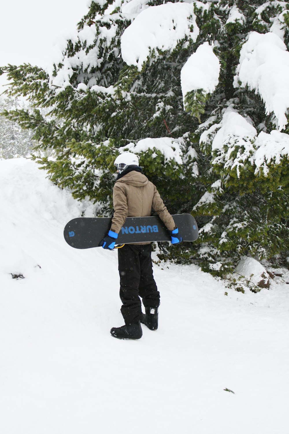 hombre de pie mientras sostiene la tabla de snowboard