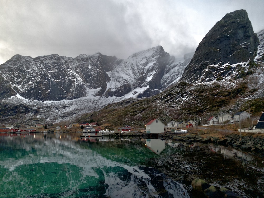 lake beside house and mountain in nature photography