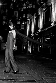 A high-profile model in a stylish evening gown, exuding elegance in a luxurious urban setting.