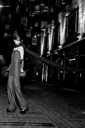 Evening wear showcased by a model in a sleek black gown against a city skyline.