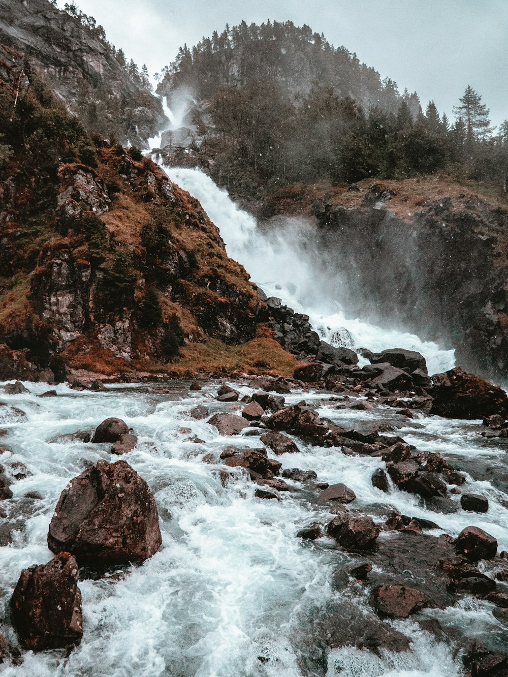 waterfalls between rocks at daytime