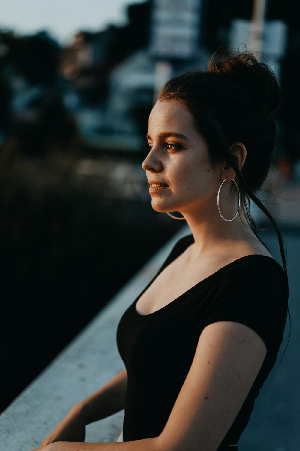 smiling woman leaning on concrete fence