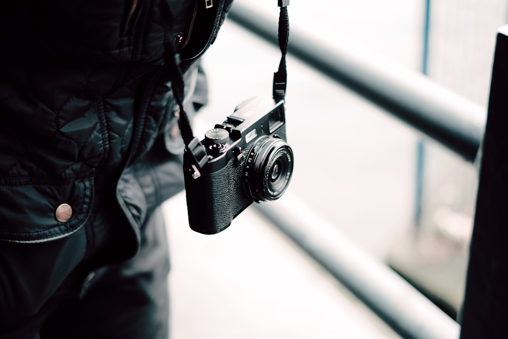 person carrying camera beside glass ball