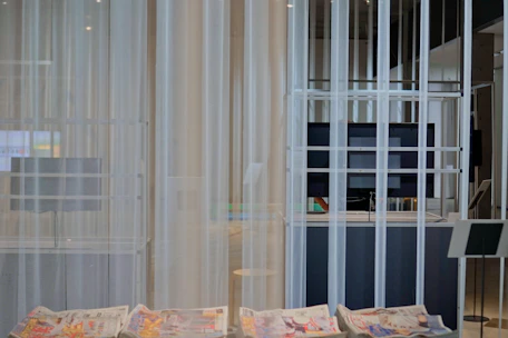 A sleek newsroom with journalists working on computers and large screens displaying news updates.