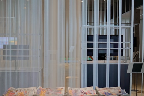 A technician installing curtains in a modern space.