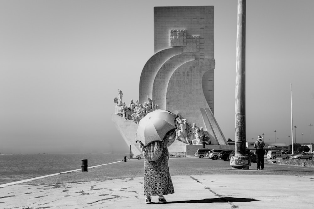 grayscale photo of person under umbrella