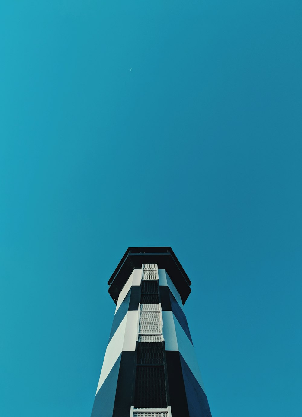 Weißer und blauer Leuchtturm in der Tiefwinkelfotografie bei Tag