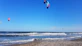 Surfer catching a vibrant kite wave off the sandy shores of Jericoacoara.