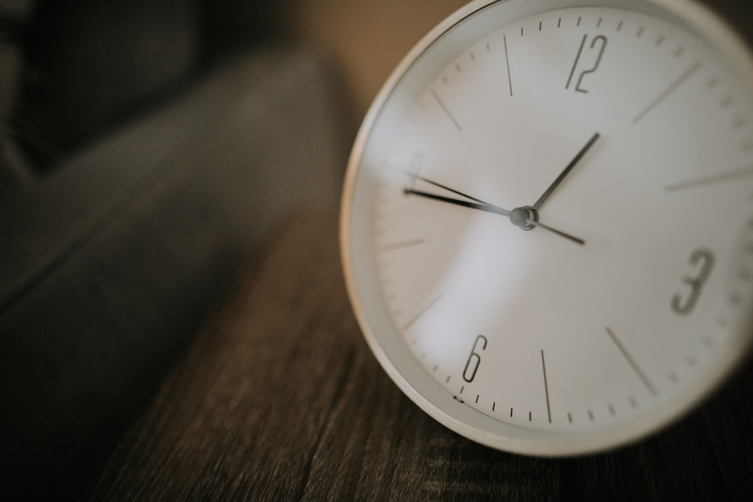 white analog wall clock with white wooden frame