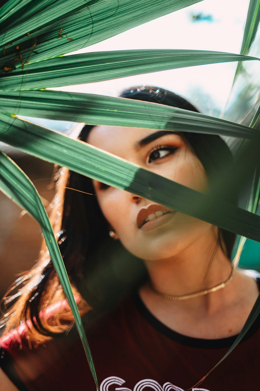 woman behind green-leafed plant