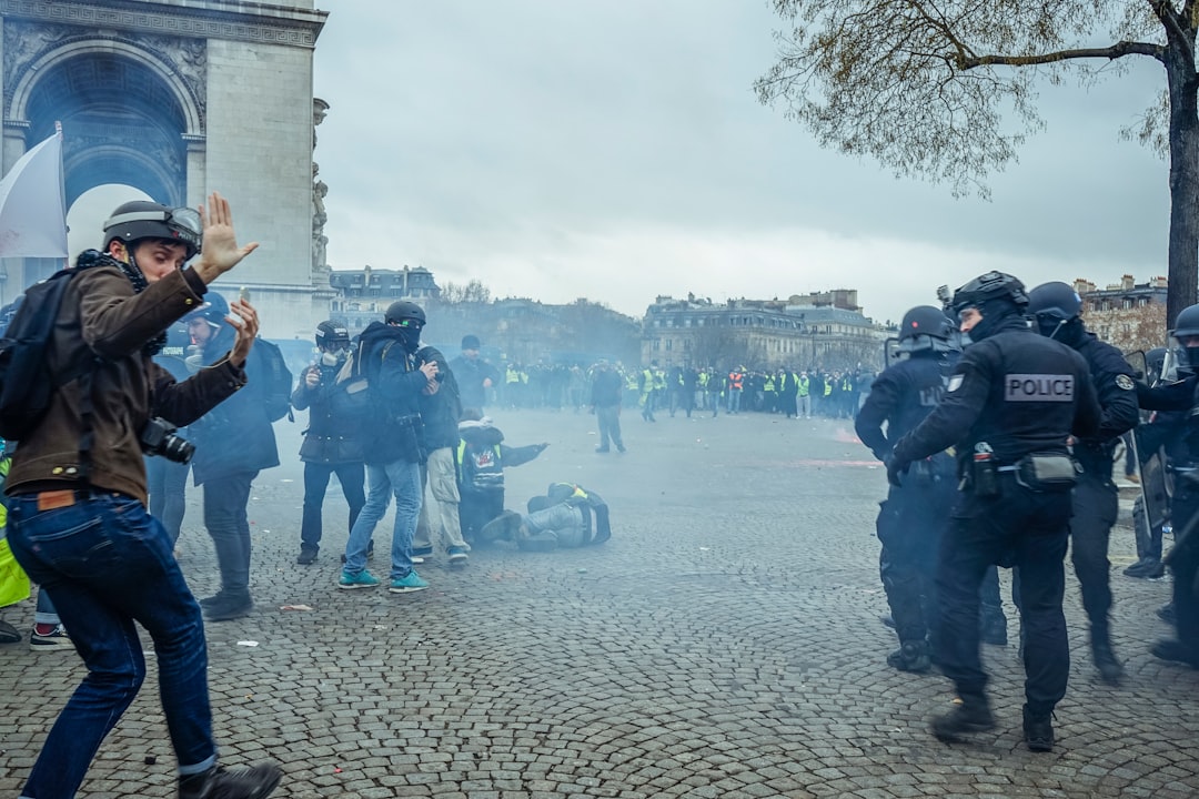 people standing and walking outside with policemen patrolling the area during daytime