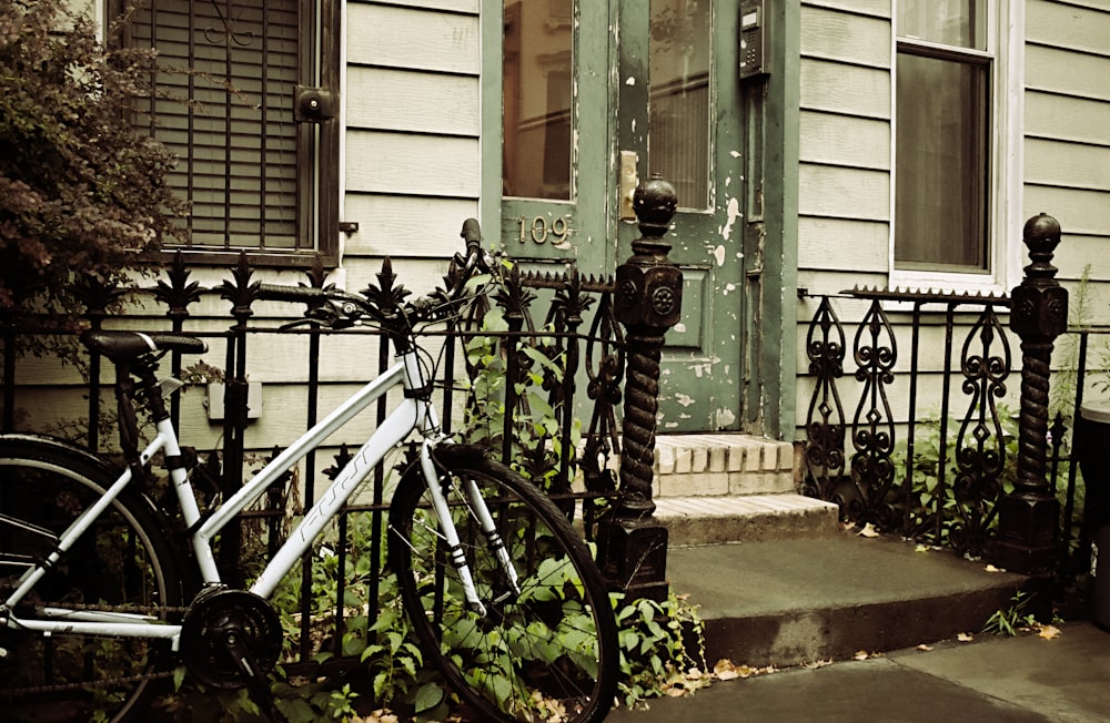 white bicycle beside gate